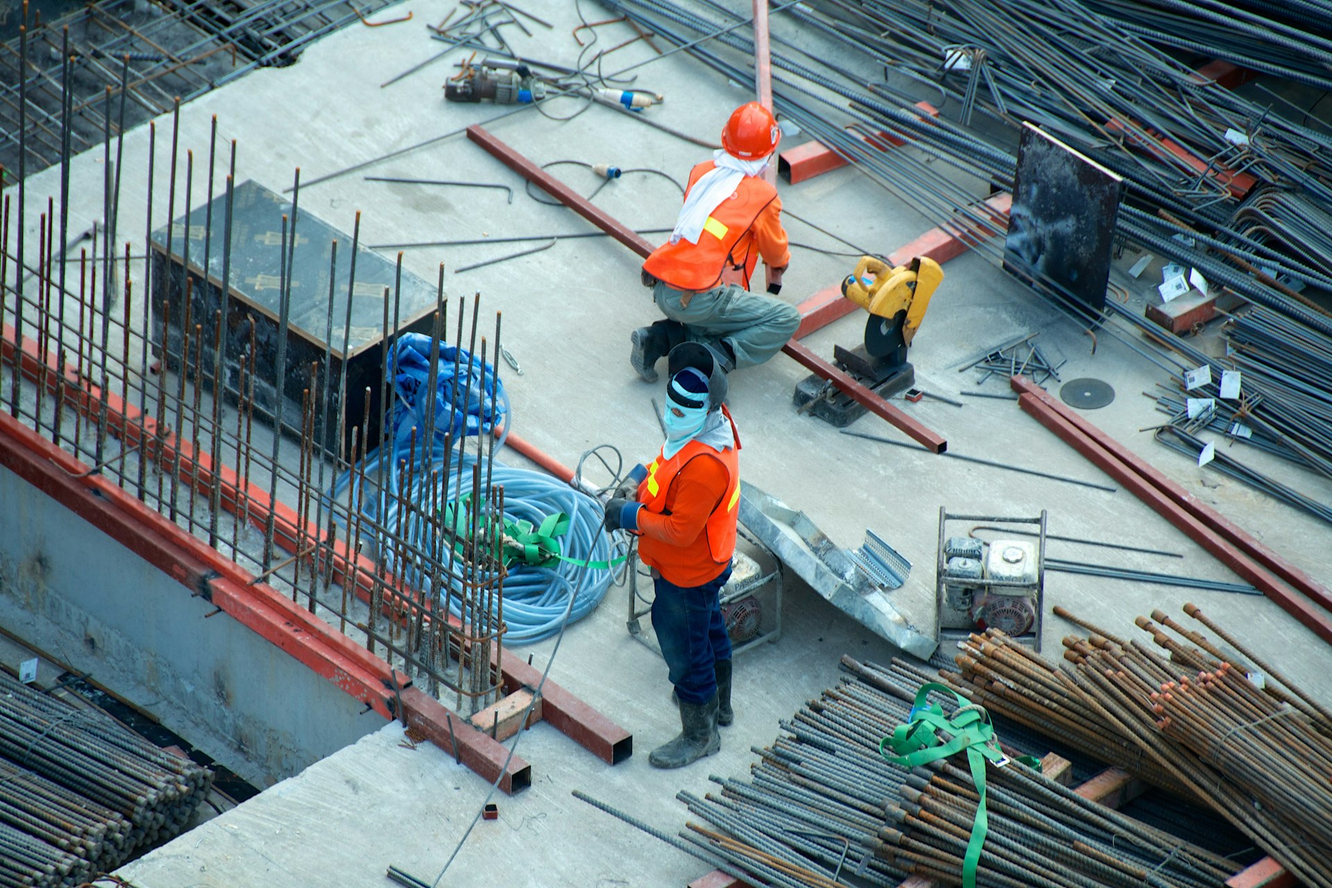 Construction workers on a job site with steel rebar and scaffolding materials, representing construction accident legal services in New York City